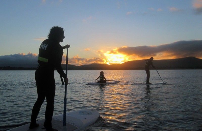 Stand up paddle boarding in Dingle harbour at sunset