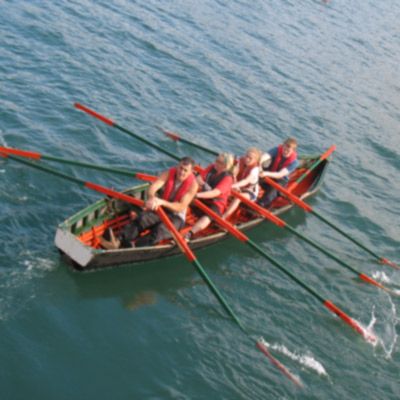 four people rowing a traditional naomhóg 