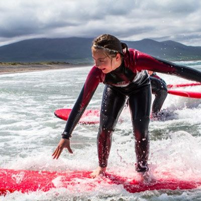 girl in the water learning to surf dingle peninsula Ireland